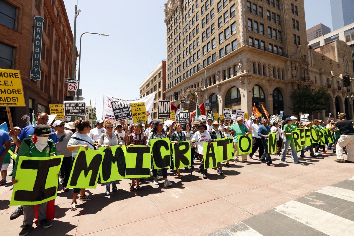 A Lynwood woman is accused of stealing the identity of an attorney and conning dozens of immigrants. Above, protesters seek immigration reform at a May Day march in downtown L.A.