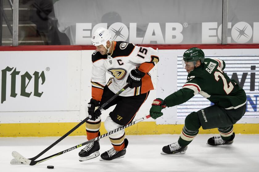 Anaheim Ducks' Ryan Getzlaf (15) is defended by Minnesota Wild's Nick Bjugstad (27) during the third period of an NHL hockey game Wednesday, March 24, 2021, in St. Paul, Minn. (AP Photo/Hannah Foslien)