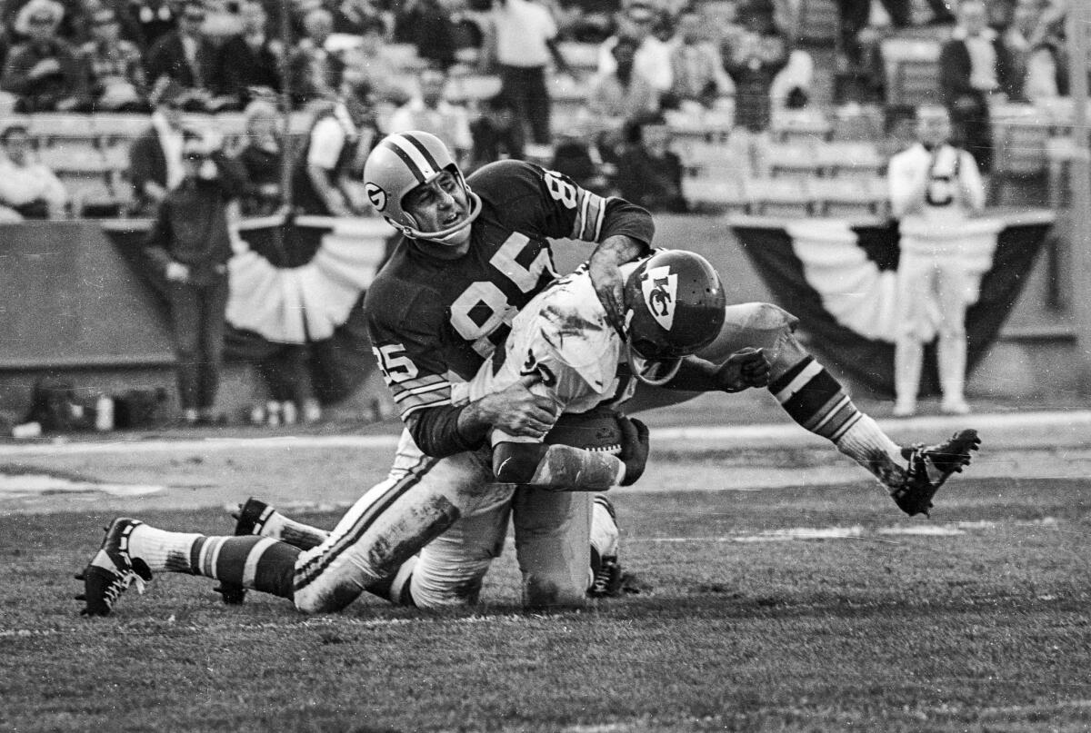 Jan. 15, 1967: Packers receiver Max McGee, 85, secures tackle of Chiefs' Willie Mitchell following interception of Bart Starr pass.