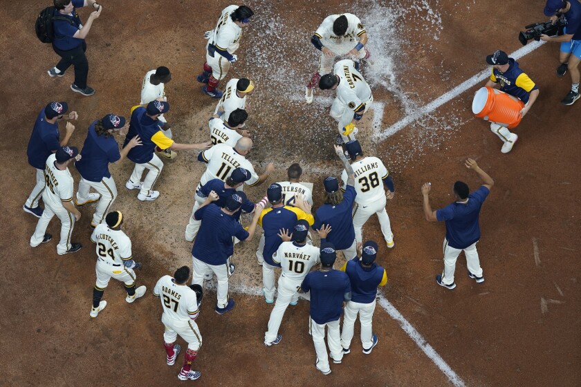 Milwaukee Brewers' Victor Caratini is congratulated after hitting a walk off three run home run during the 10th inning of a baseball game against the Chicago Cubs Monday, July 4, 2022, in Milwaukee. (AP Photo/Morry Gash)