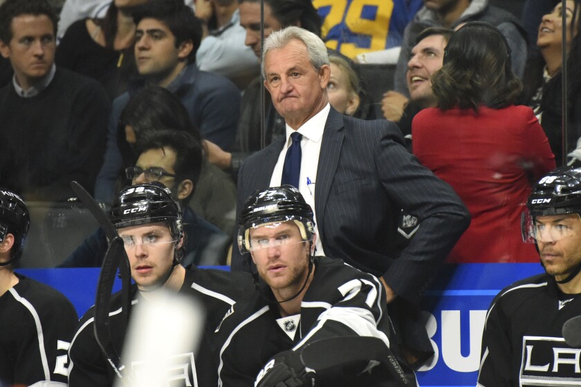 Kings coach Darryl Sutter looks on during a hockey game.