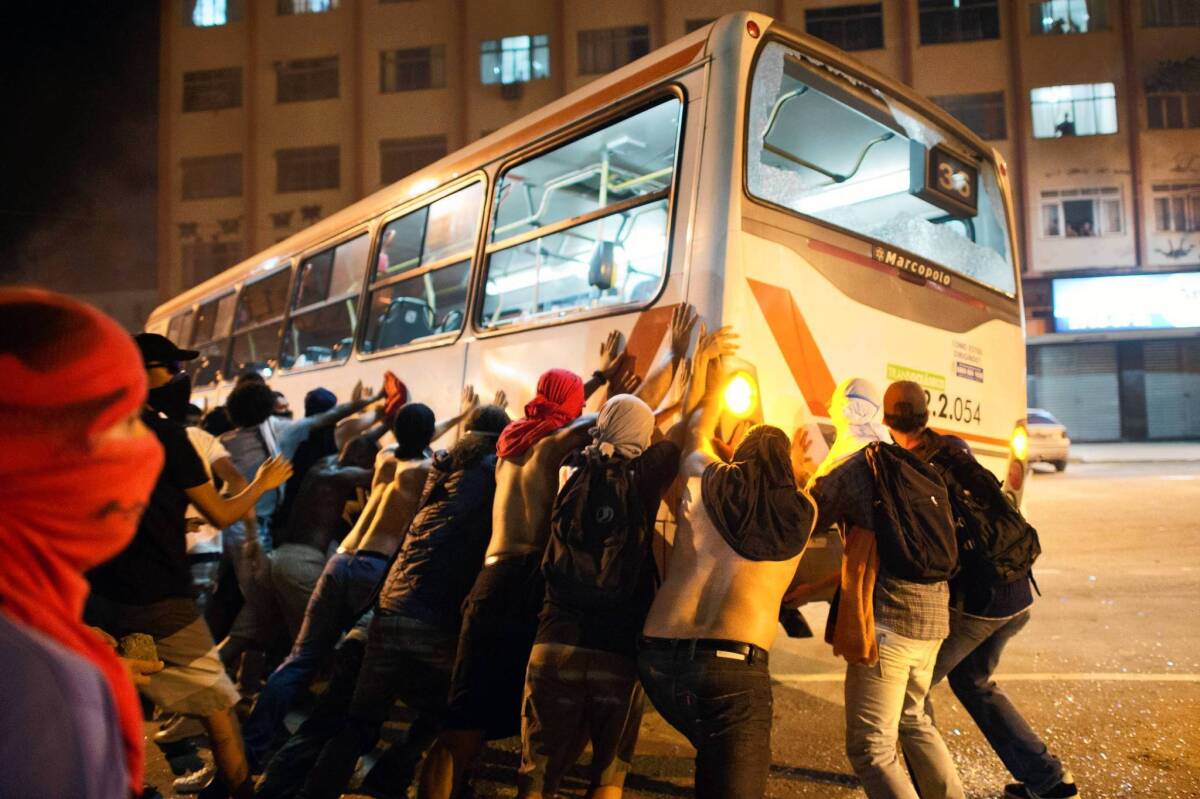 Demonstrators in Niteroi, near Rio de Janeiro, overturn a bus during protests. Clashes with police continued even as bus fare hikes were rolled back in two cities after protests.