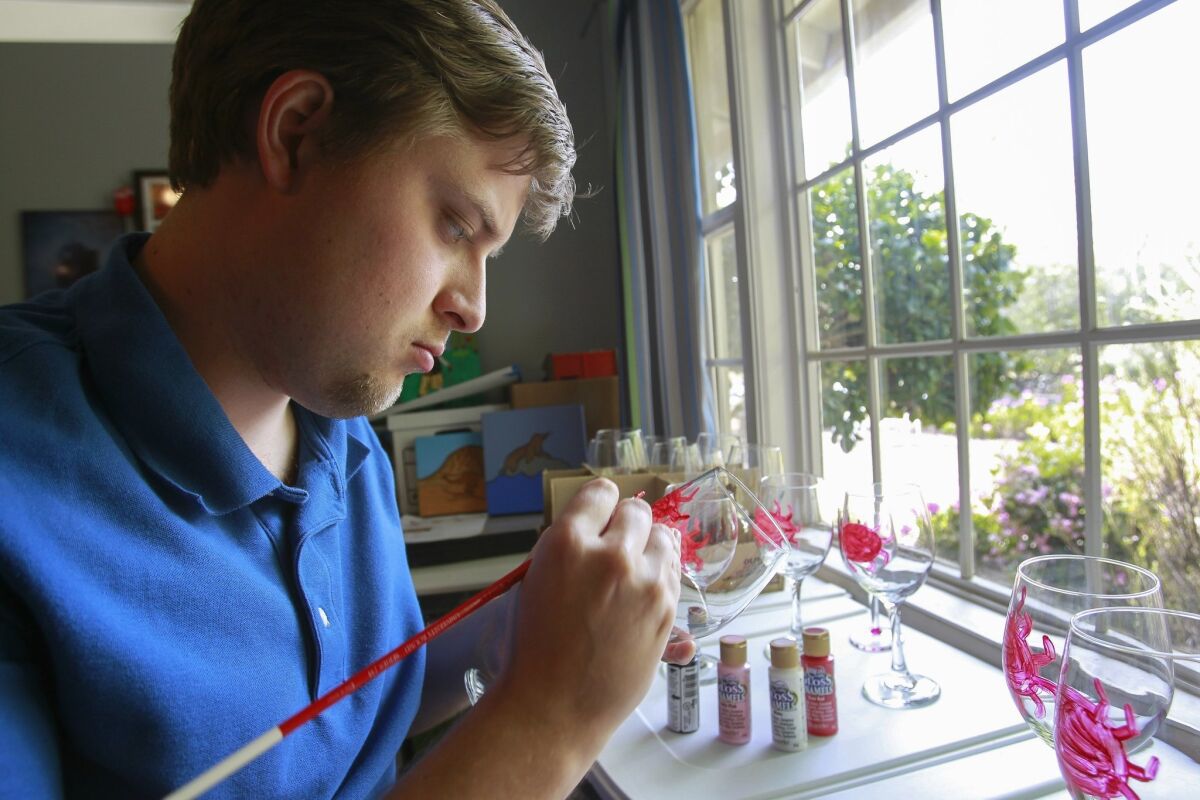 Autistic artist Joel Anderson, 23, paints crabs on wine glasses while in his studio at his home in Fallbrook on Monday. HAYNE PALMOUR /UT San Diego/Copyright 2014 San Diego Union-Tribune, LLC