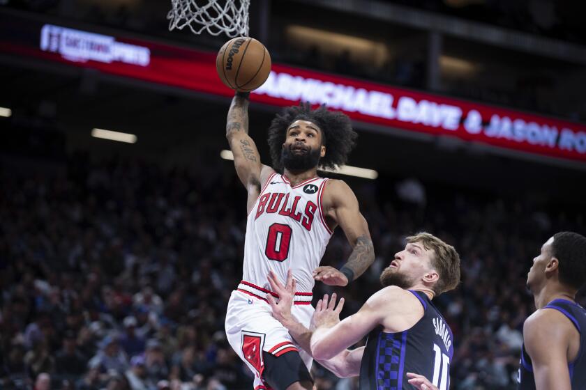 Coby White (0), de los Bulls de Chicago, anota ante su rival de los Kings de Sacramento Domantas Sabonis (10) en la segunda mitad del partido de la NBA que enfrentó a ambos equipos en Sacramento, California, el 4 de marzo de 2024. (AP Foto/José Luis Villegas)