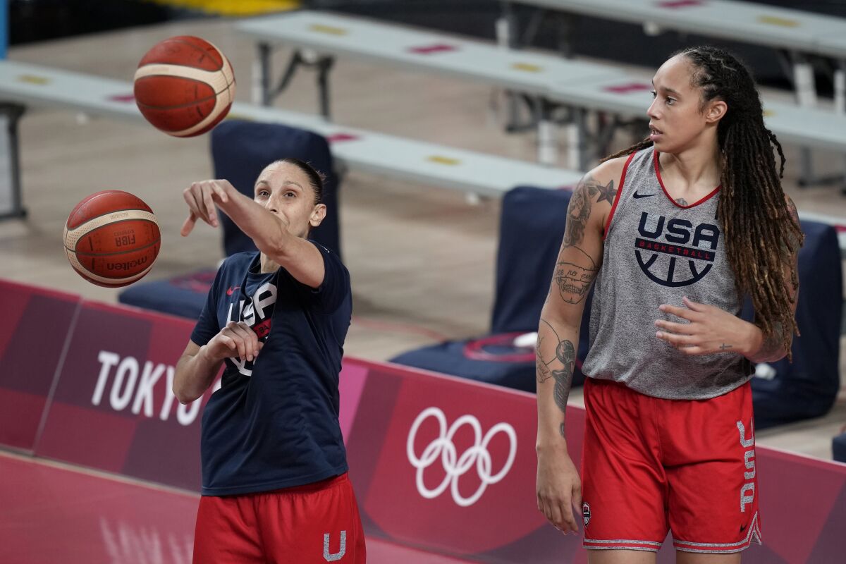 FILE - United States' Diana Taurasi, left, and Brittney Griner tale part in a women's basketball practice at the 2020 Summer Olympics, July 24, 2021, in Saitama, Japan. Taurasi’s USA Basketball career isn’t done just yet. The five-time Olympic gold medalist is part of the national team training camp in Minnesota next month. While Taurasi will be at the camp, Brittney Griner won’t. She is still part of the pool that the 2024 Olympic team will be chosen from. (AP Photo/Eric Gay, file)