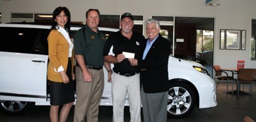 Bob Baker (above, far right) presents the check to Steve Gulley, president of the Lemon Grove Little League.