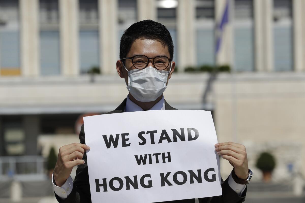 FILE - In this Aug. 25, 2020, file photo, Hong Kong activist Nathan Law takes part in a protest during a meeting of Chinese Foreign Minister Wang Yi with Italian Foreign Minister Luigi Di Maio, in Rome. Hong Kong democracy activists have launched a new push to continue their fight among residents living abroad in the wake of a sweeping crackdown by Beijing and changes to the the semi-autonomous Chinese city's electoral system aimed at shutting out opposition voices. (AP Photo/Andrew Medichini, file)
