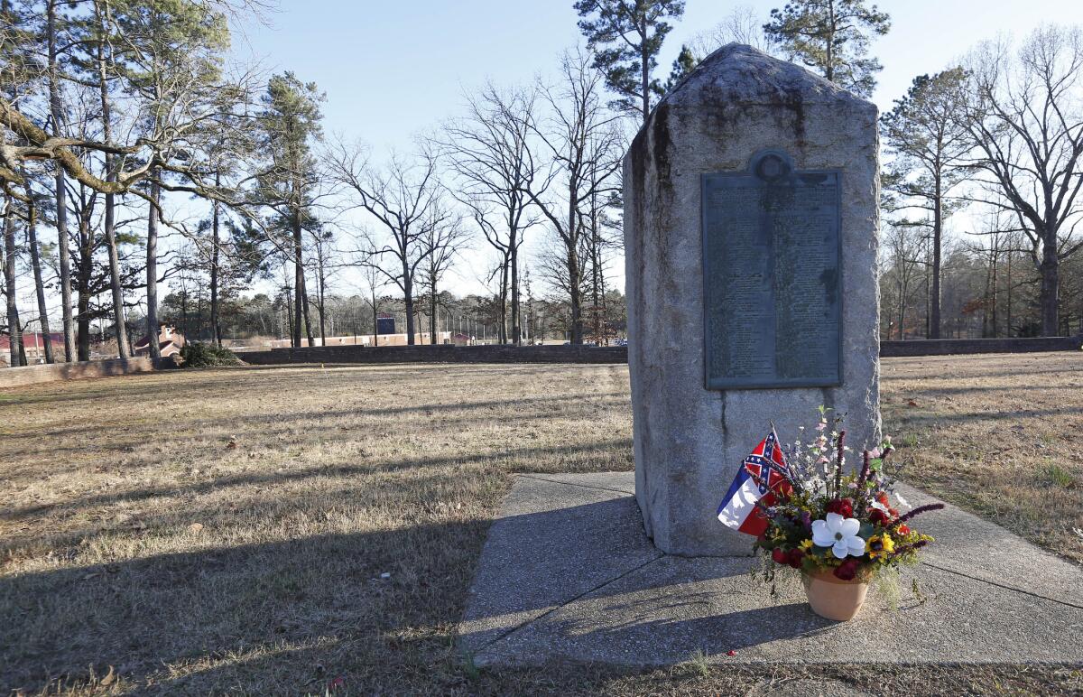 A memorial marker standing in the University of Mississippi campus cemetery that has the graves of Confederate soldiers.