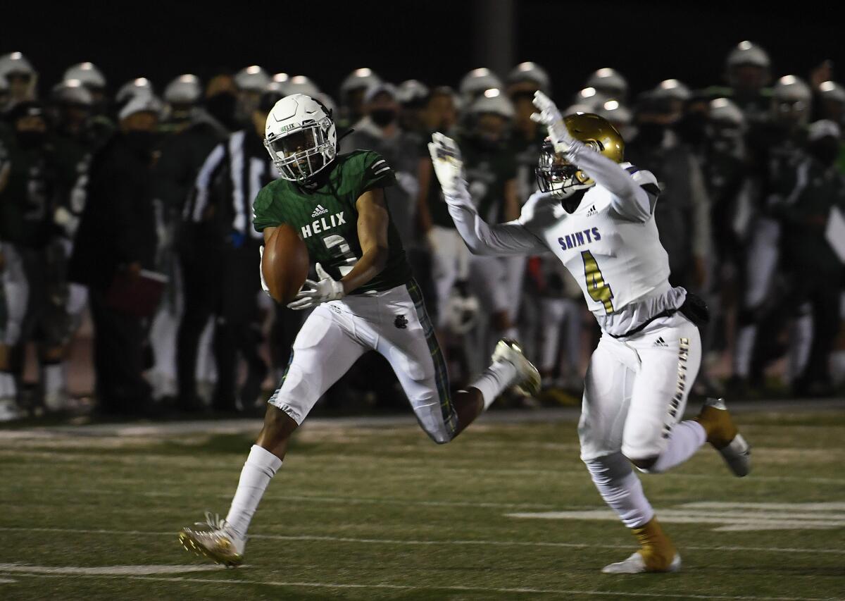 Helix High's Xavier Van fights for a pass with St. Augustine's DJ Overstreet during the first half of Friday night's game.