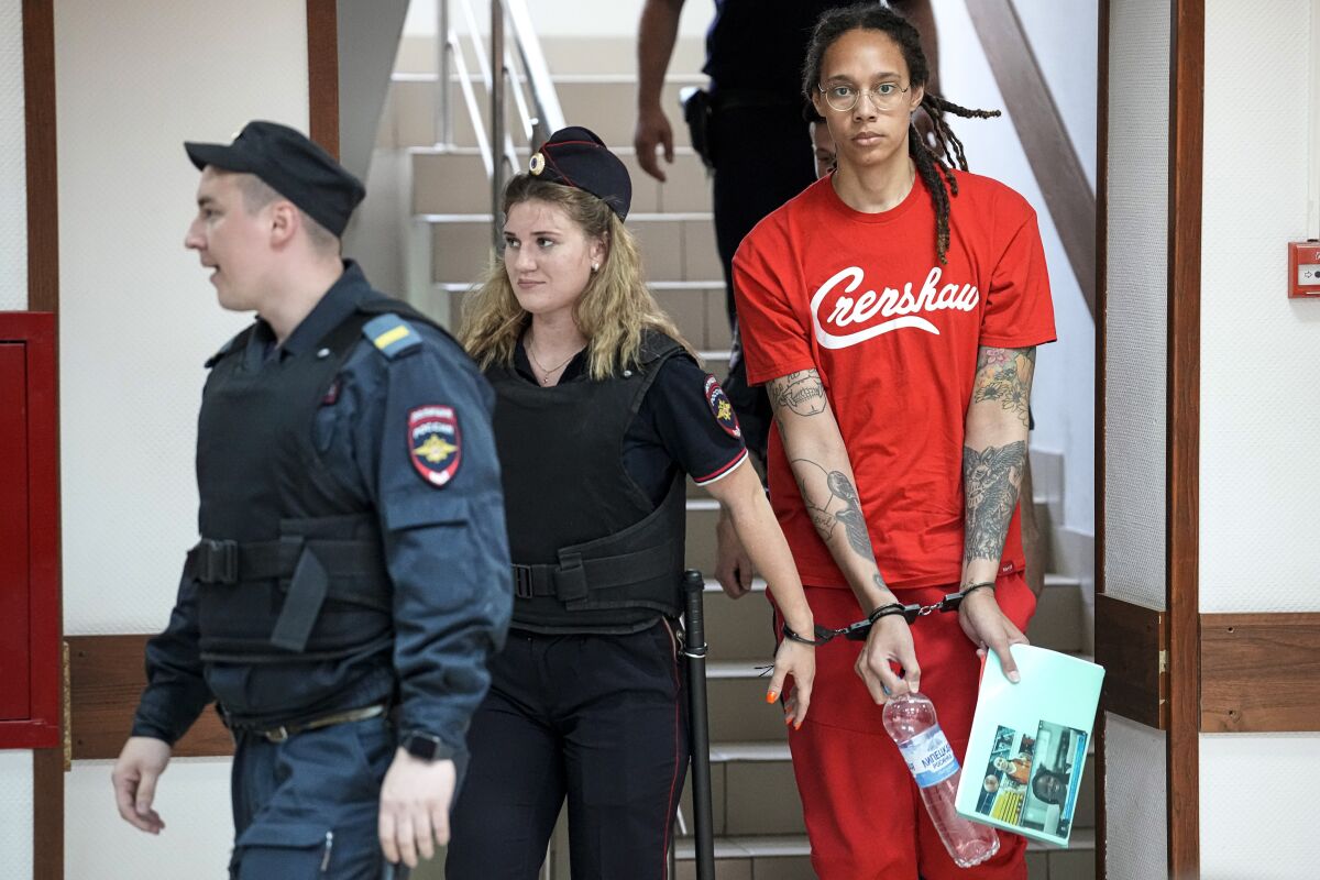 Basketball player Brittney Griner wears a red T-shirt with the word "Crenshaw" while walking down stairs
