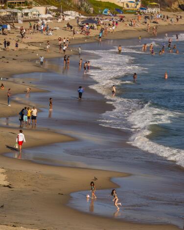 Laguna Beach, CA - June 20: Beach goers enjoy cooling off at Main Beach in Laguna Beach Thursday, June 20, 2024. (Allen J. Schaben / Los Angeles Times)