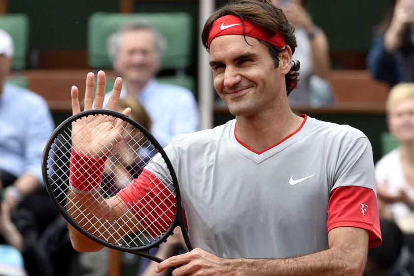 Roger Federer waves at the crowd after winning his first-round match at the French Open on Sunday.