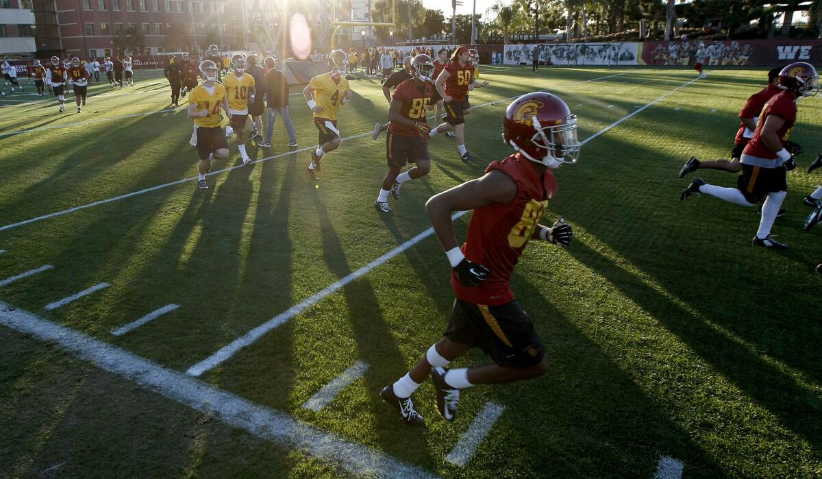 The Trojans football team runs a lap on the first day of spring practice on March 8.