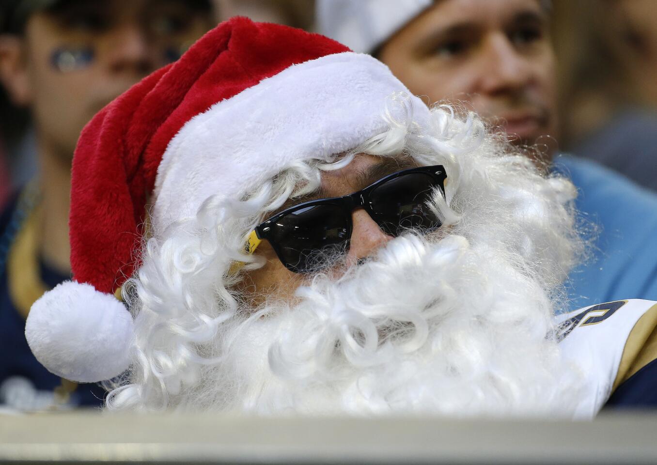 A Los Angeles Rams fan wears a Santa hat and beard during the second half of an NFL football game against the Arizona Cardinals, Sunday, Dec. 23, 2018, in Glendale, Ariz.