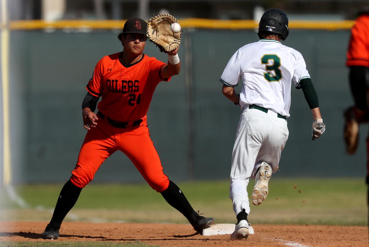 Huntington Beach's Ralph Velazquez (24), fields an out at first base against Edison in March.