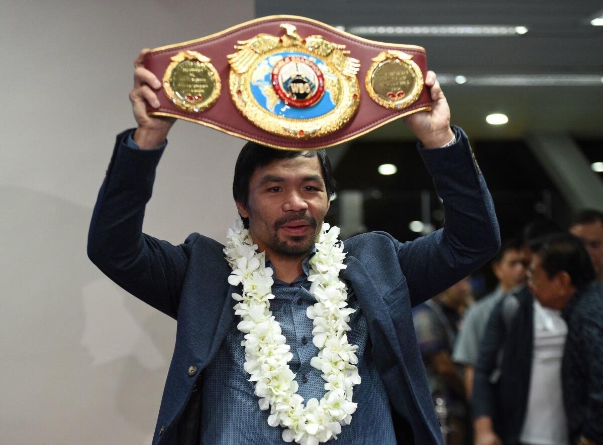 In this photo taken on November 8, 2016 shows Philippine boxing icon Manny Pacquiao holding his welterweight title belt after defeating Mexican boxer Jessie Vargas, shortly after arriving at Manila airport. Pacquiao and British fighter Amir Khan confirmed separately on February 26, 2017 that they would face each other on April 23 after weeks of conflicting reports. / AFP PHOTO / TED ALJIBETED ALJIBE/AFP/Getty Images ** OUTS - ELSENT, FPG, CM - OUTS * NM, PH, VA if sourced by CT, LA or MoD **