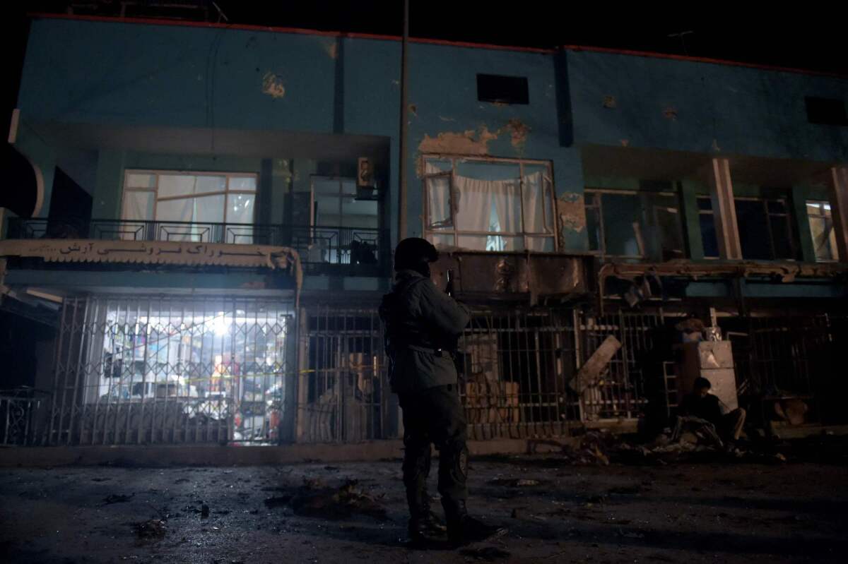 An Afghan policeman keeps watch at the site of suicide car bomb attack against a vehicle carrying employees of the Afghan TV channel Tolo in Kabul on Jan. 20.