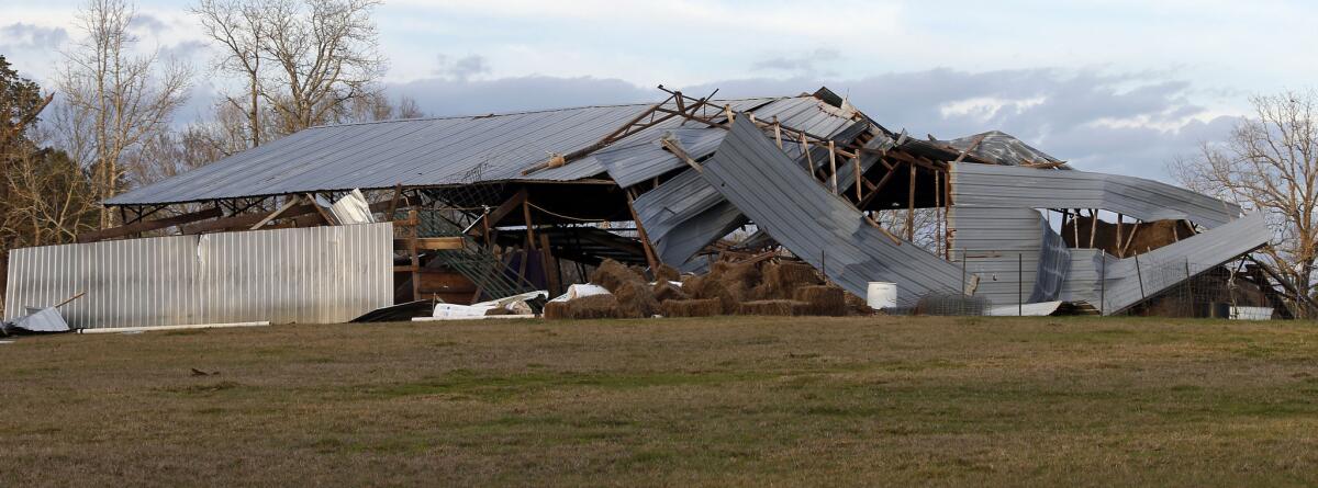 Hay bales sit outside a farm shed that was heavily damaged by recent storms in rural Copiah County, Miss.