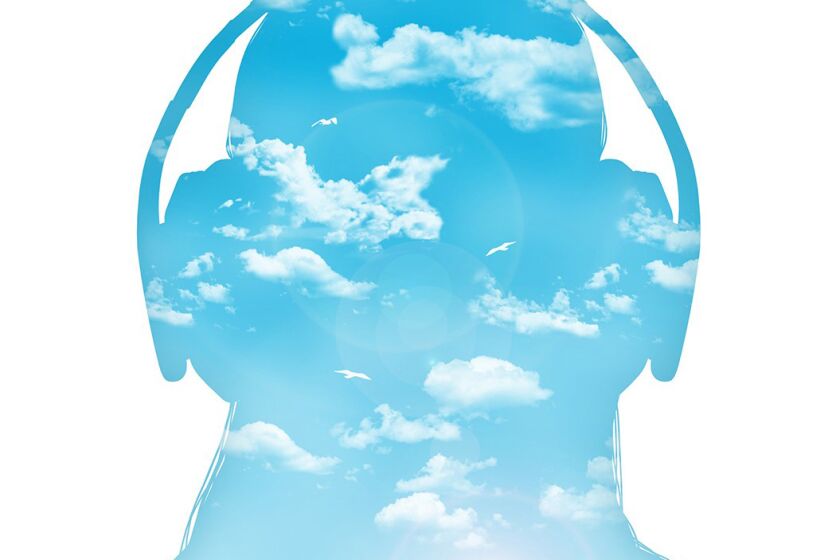 silhouette of a young woman in headphones listening to the music, beautiful blue sea landscape inside her
