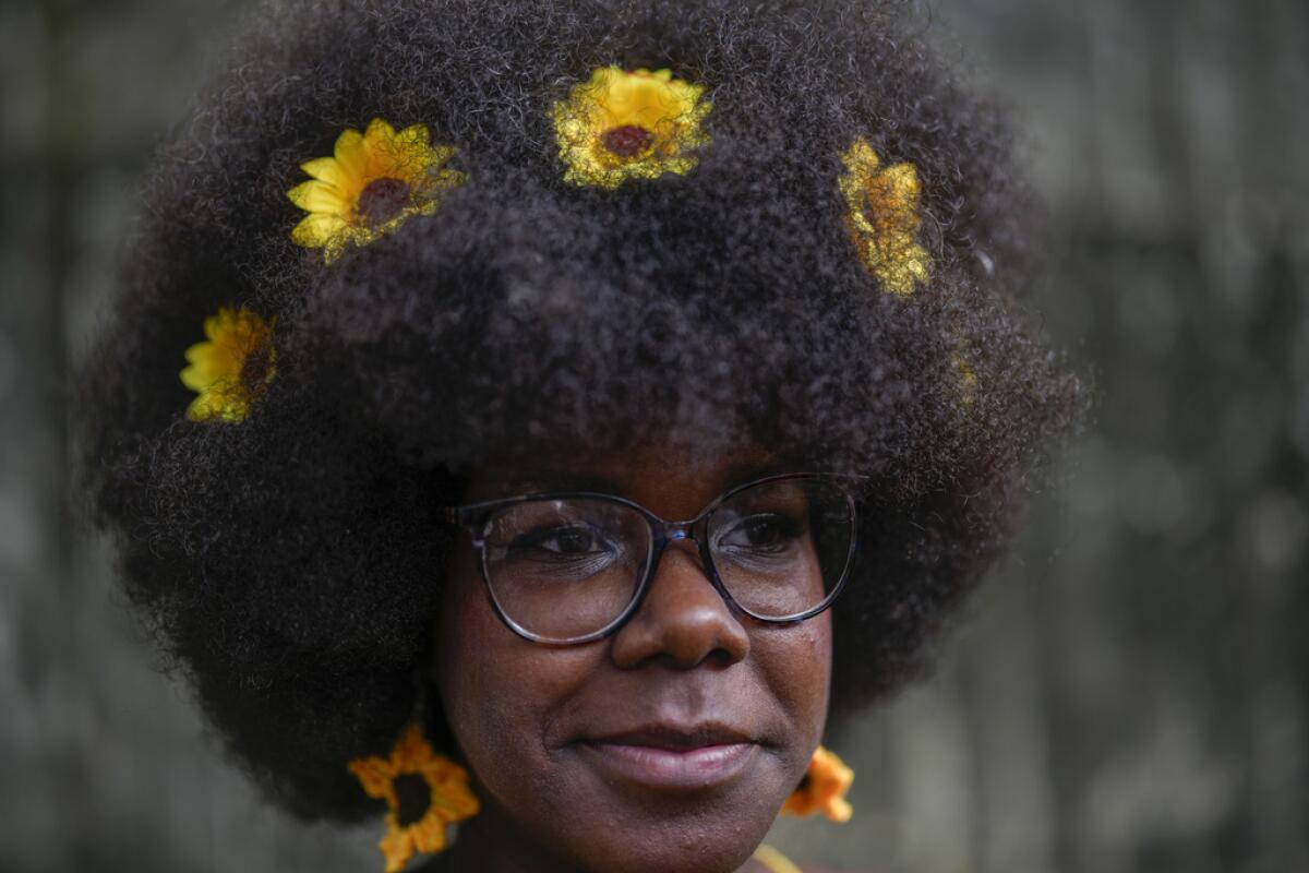 Una mujer con girasoles en el pelo espera para caminar por la pasarela