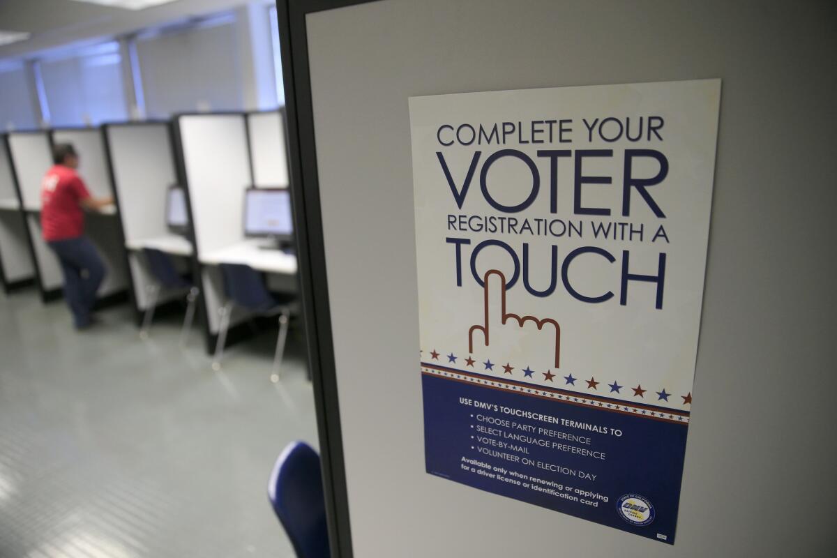 A sign advertises a touch-screen machine for voter registration at the Department of Motor Vehicles in Santa Ana, Calif.