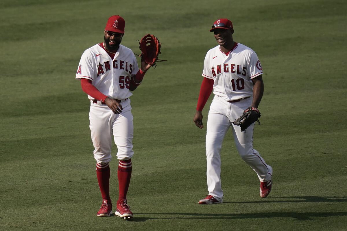 Los Angeles Angels' Jo Adell, left, and Justin Upton laugh as they celebrate their win over the Houston Astros.