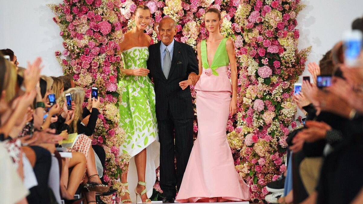 Designer Oscar de la Renta takes a bow with models Karlie Kloss, left, and Daria Strokous after his spring 2015 collection is modeled during Fashion Week in New York.