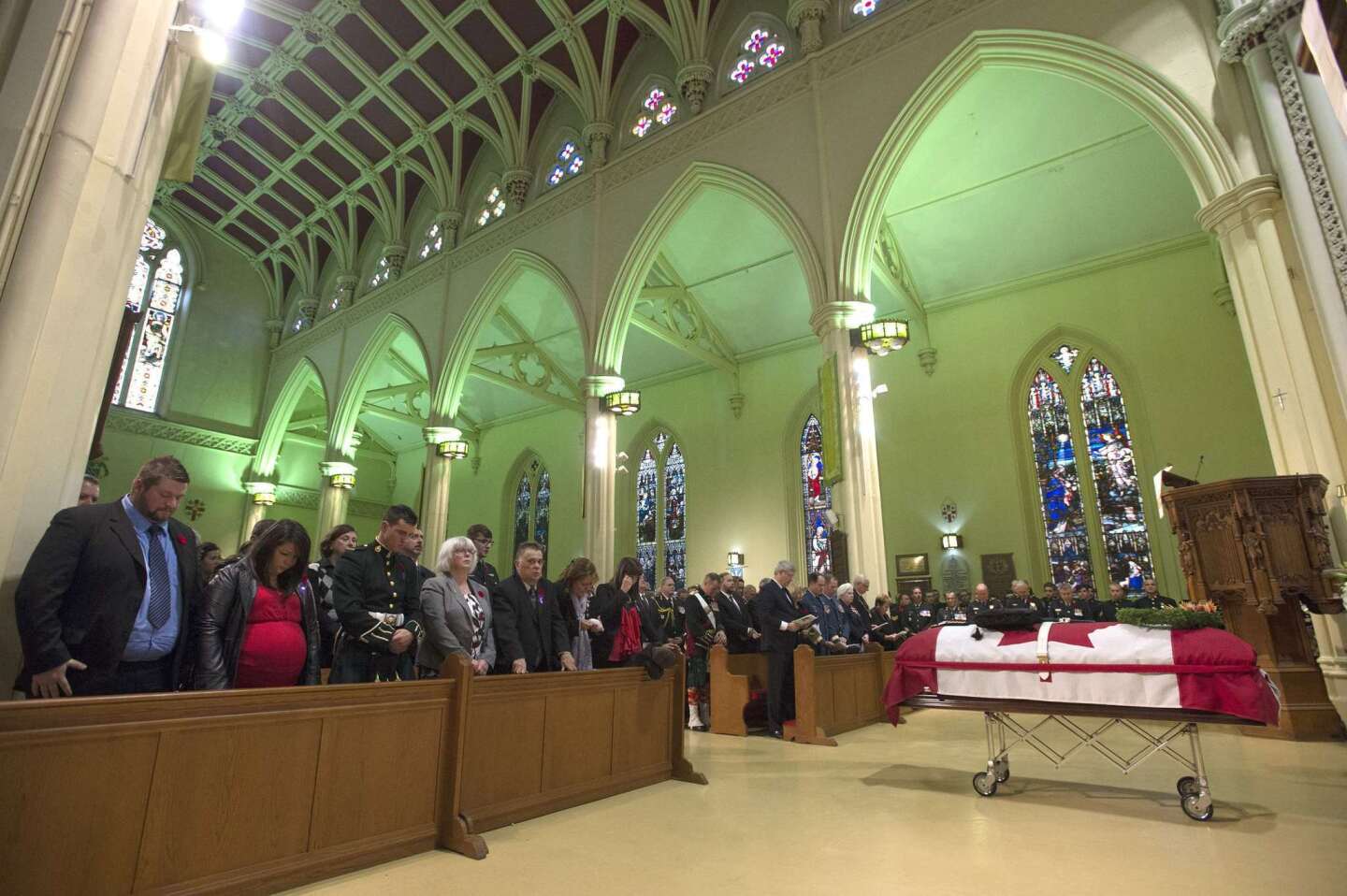People bow their heads during the regimental funeral service for Cpl. Nathan Cirillo in Hamilton, Ontario