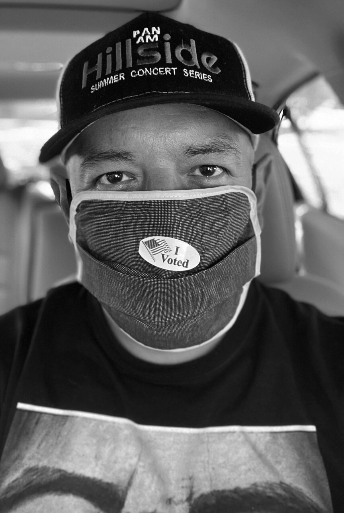 Biden supporter Paul Saldaña wears a mask in this black-and-white selfie taken inside a car.
