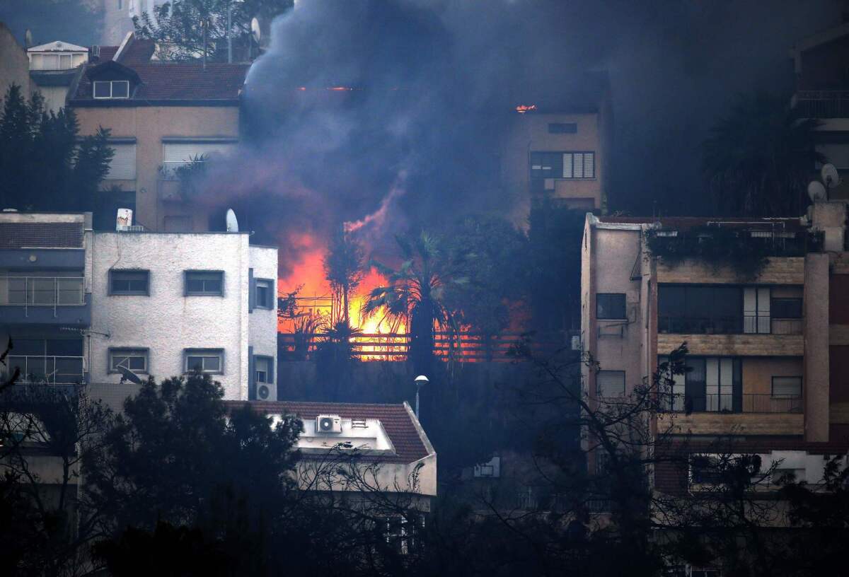 Smoke billows from a house in the northern Israeli port city of Haifa.