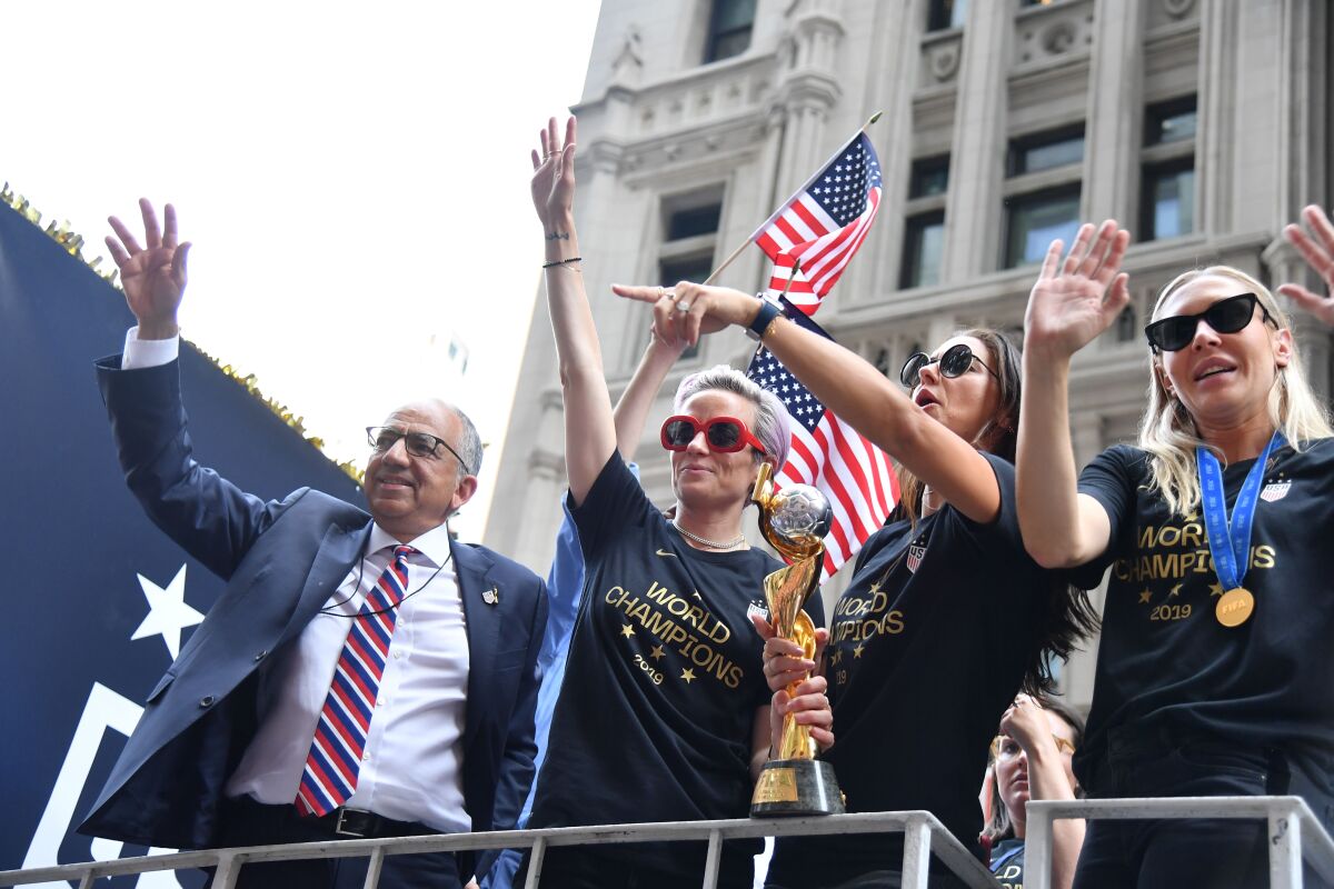 U.S. Soccer president Carlos Cordeiro stands with Megan Rapinoe, left, Alex Morgan and Allie Long before a ticker-tape parade to celebrate the women's national team's World Cup title July 10 in New York.