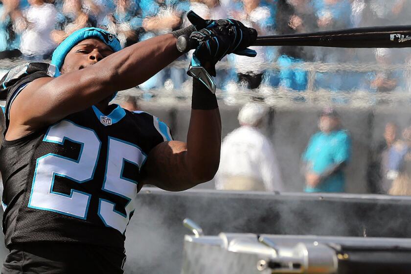 Panthers defender Bene Benwikere swings a bat as he takes the field to play the Atlanta Falcons on Dec. 13.