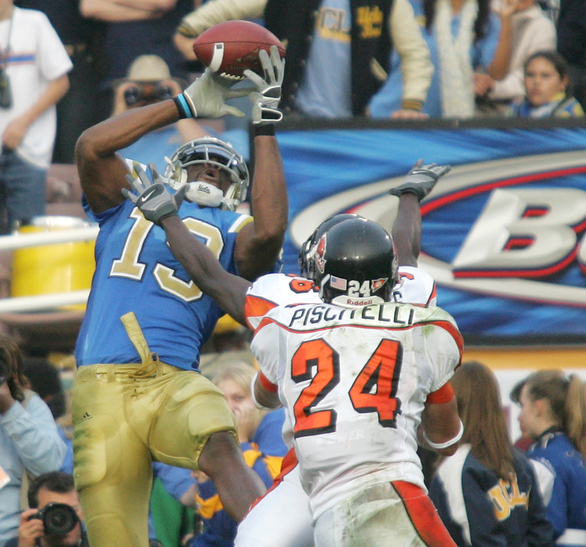 UCLA wide receiver Mercedes Lewis catches a touchdown pass over Oregon State's Brandon Hughes and Sabby Piscitelli.