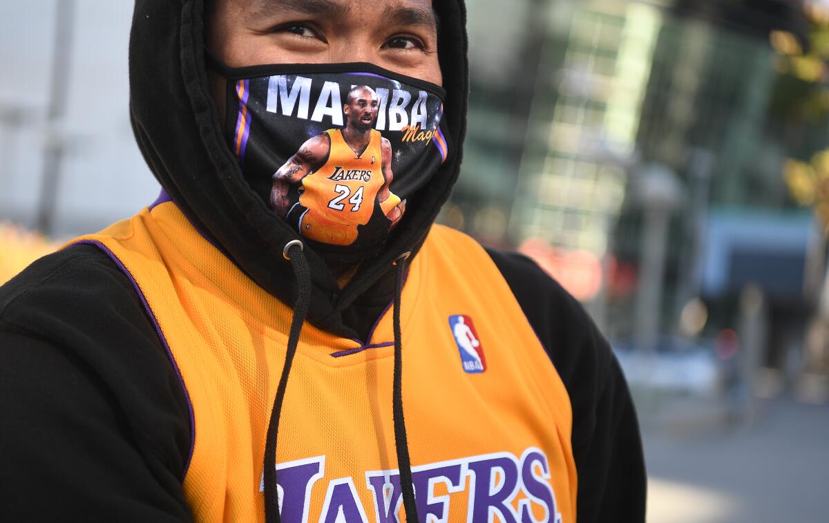 Randolf Garrido wears a hoodie, Lakers jersey and a mask with an image of Kobe Bryant and the words "Mamba magic."