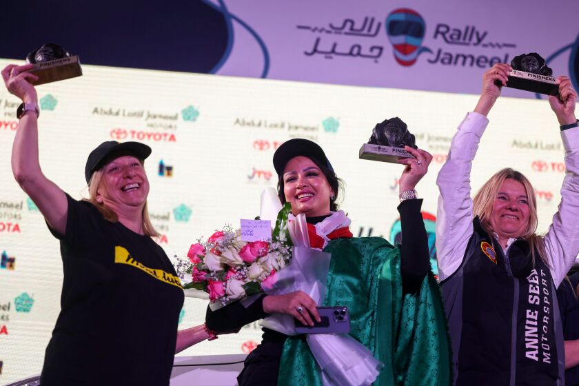 Saudi driver Maha al-Hamly (center) and co-driver Pochola Hernandez (left) are joined by rally winner Annie Seel.
