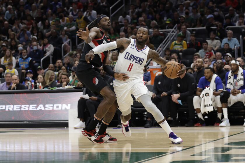 Los Angeles Clippers' John Wall drives past Portland Trailblazers' Jerami Grant during the first half of a preseason NBA basketball game, Monday, Oct. 3, 2022, in Seattle. (AP Photo/ John Froschauer)