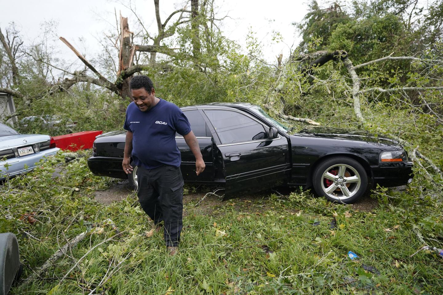 A car smashed by a tree is among damage at Reginald Duhon's Lake Charles home.