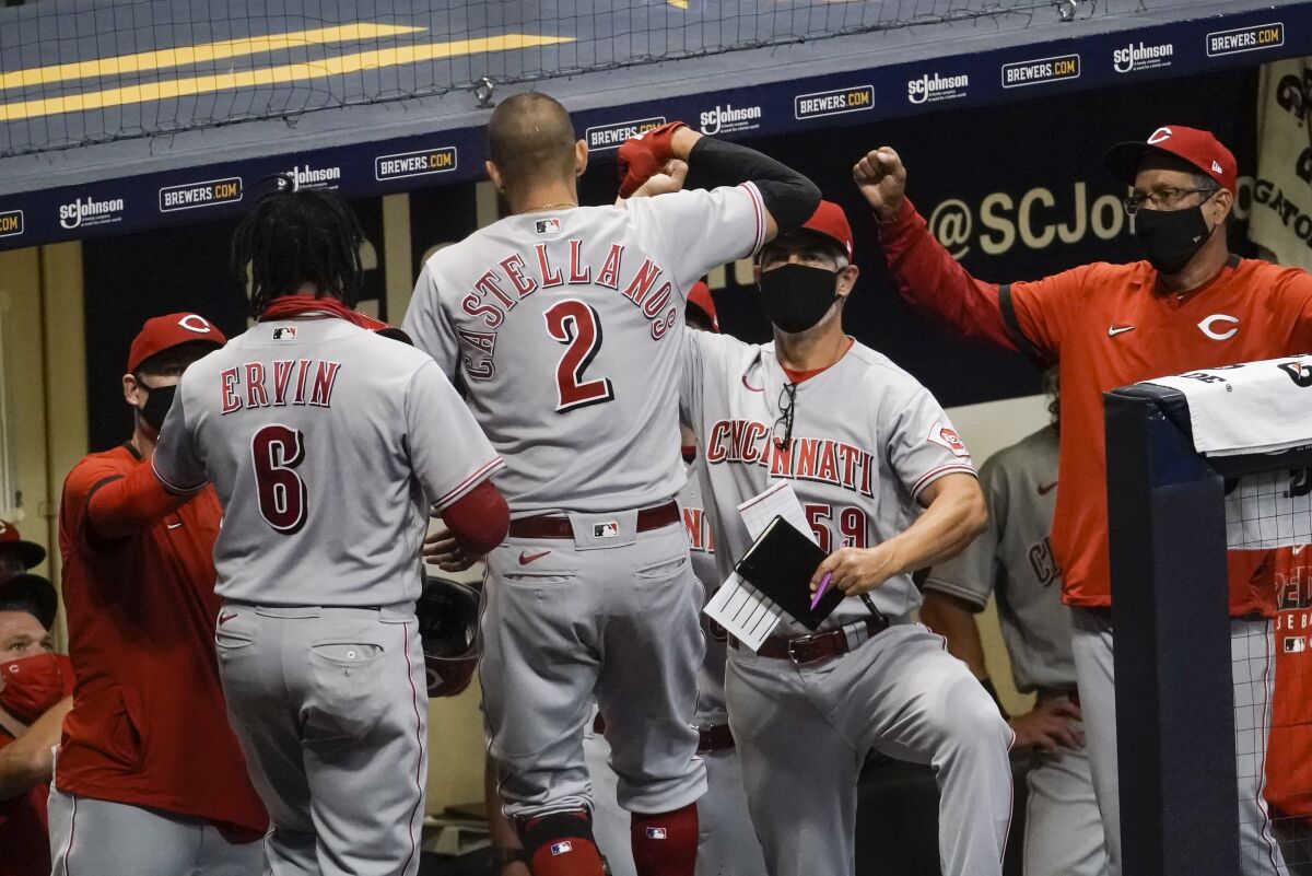 Cincinnati Reds' Nicholas Castellanos is congratulated after hitting a two-run home run during the sixth inning of a baseball game against the Milwaukee Brewers Friday, Aug. 7, 2020, in Milwaukee. (AP Photo/Morry Gash)