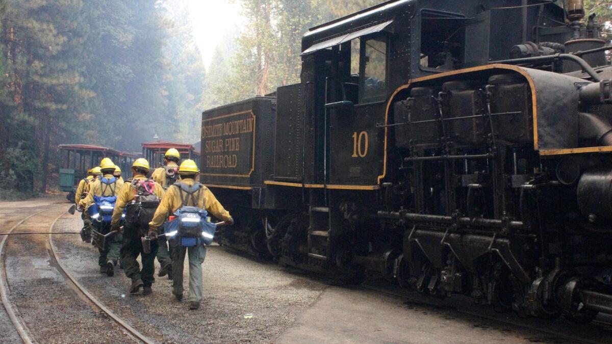 A U.S. Forest Service hand crew out of Fresno walks toward a spot fire at the Yosemite Mountain Sugar Pine Railroad in Fish Camp, Calif., on Aug. 29.