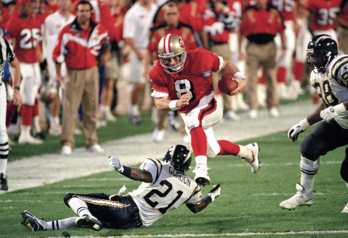  San Francisco 49ers' quarterback Steve Young (8) runs over San Diego's Darrien Gordon (21) in Super Bowl XXIX.