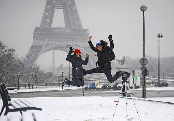 Unidentified Japanese tourists pose for a picture in front of the Eiffel Tower in Paris.
