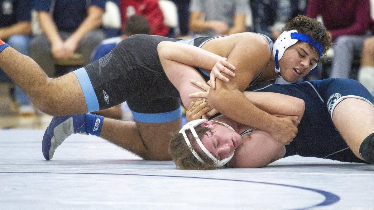 Corona del Mar High's Emilio Franco attempts to pin Newport Harbor's JJ Perez in the 200-pound bout during a Wave League match on Wednesday.