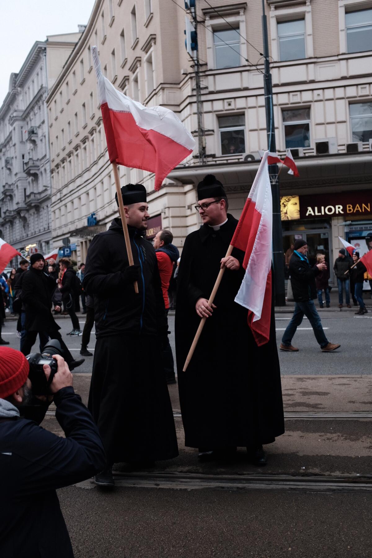 Priests pose with Polish flags in Warsaw during the Independence Day march organized by ultranationalists on Nov. 11, 2019. Although the Church of Poland distances itself from the event, the march is packed with religious insignia and slogans and is attended by religious Poles.