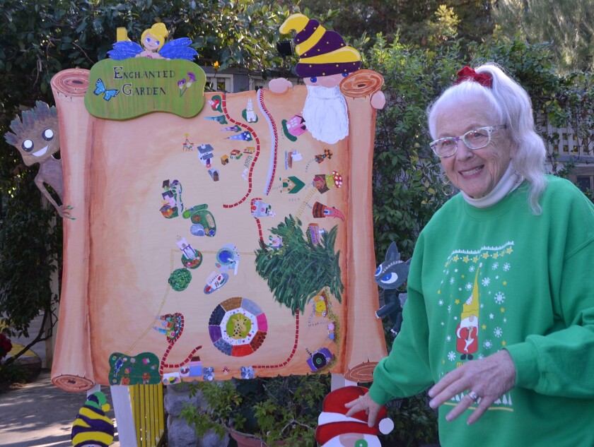 Bejai Higgins stands in front of the map of the Enchanted Garden, which she created with her husband at their Poway home.
