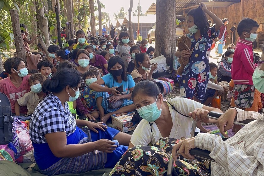 Myanmar villagers rest in an evacuation area after fleeing to Thailand following clashes between Myanmar troops and an ethnic Karen rebel group Friday, Dec. 17, 2021, in Mae Tao, Tak province, northern Thailand. Fighting between Myanmar government forces and ethnic guerrillas has sent about 2,500 villagers fleeing across the border into Thailand, a Thai army officer said Friday. (AP Photo/Chiraunth Rungjamratratsami)