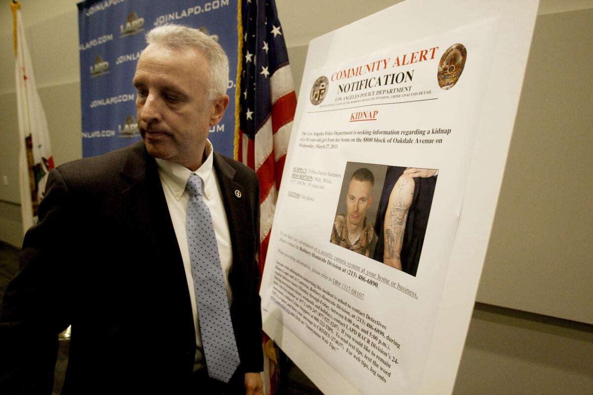 LAPD Lt. Walter Teague shows a poster board asking for the public's help in locating kidnapping suspect Tobias Dustin Summers.