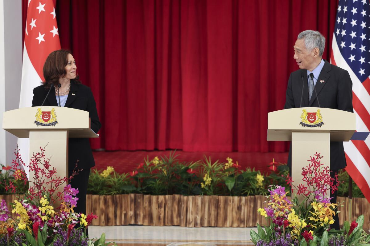 U.S. Vice President Kamala Harris and Singapore Prime Minister Lee Hsien Loong look at each other while standing