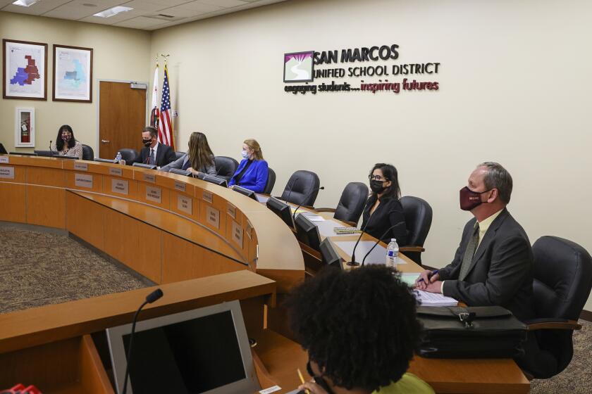 SAN MARCOS, CA - FEBRUARY 15: Members of the San Marcos Unified School District watch as San Marcos teachers and their supporters protest the offer of 0 percent raises during a district meeting at San Marcos Unified School District offices on Tuesday, Feb. 15, 2022 in San Marcos, CA. (Eduardo Contreras / The San Diego Union-Tribune)