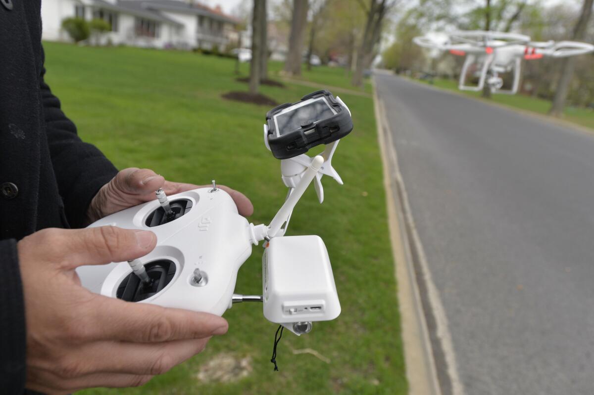 Two men were arrested when a DJI Phantom II model drone like the one seen here had a near-miss with a New York Police Department helicopter, police said.