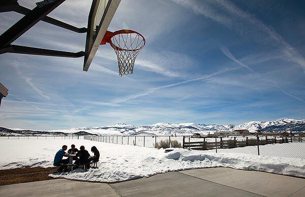 Snow covers the playground as students eat their lunch outside Eastern Sierra Academy in Bridgeport, Calif. The 15-year-old technology-based academy, which has three full-time teachers and one half-time Spanish-language teacher for merely 22 students, has been ordered closed because of the Eastern Sierra Unified School District's $1.8-million budget shortfall.